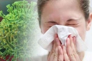 Persoană care poartă mască și tușește – simptome ale infecțiilor virale respiratorii.